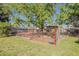 View of backyard with manicured lawn, and a large fenced off area with a sign at 125 N Fraser E Dr, Mesa, AZ 85203