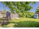 Backyard with outbuilding, fenced area, lush lawn, and mature trees at 125 N Fraser E Dr, Mesa, AZ 85203