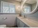 Well-maintained bathroom with vanity, bright lighting, and a round mirror at 125 N Fraser E Dr, Mesa, AZ 85203