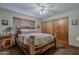 Cozy bedroom with unique wooden bed frame, closet, and blind-covered window at 125 N Fraser E Dr, Mesa, AZ 85203