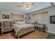 Bright bedroom with wood floors, fan, and a comfy chair near the bed at 125 N Fraser E Dr, Mesa, AZ 85203