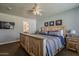 Bright bedroom featuring a ceiling fan, natural wood accents, and ensuite bathroom access at 125 N Fraser E Dr, Mesa, AZ 85203