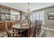 Elegant dining room with wood table, seating for eight, a sparkling chandelier, and natural light at 125 N Fraser E Dr, Mesa, AZ 85203