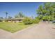 Charming brick home with manicured lawn, mature trees, and long driveway at 125 N Fraser E Dr, Mesa, AZ 85203