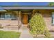 Inviting front entrance with brick facade, modern wood door, and lush greenery at 125 N Fraser E Dr, Mesa, AZ 85203