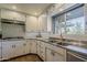 Well-lit kitchen featuring stainless steel appliances, a deep sink, ample counter space and white cabinetry at 125 N Fraser E Dr, Mesa, AZ 85203