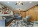 Spacious living room features ceiling fan, wood paneling and hardwood floors with built-in shelving at 125 N Fraser E Dr, Mesa, AZ 85203