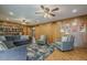 Large living room with ceiling fan, hardwood floors, wood paneling, and comfortable seating at 125 N Fraser E Dr, Mesa, AZ 85203