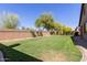 Open backyard with a well-maintained lawn and brick wall, offering a private and enjoyable outdoor space at 14556 W Shaw Butte Dr, Surprise, AZ 85379