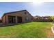 Wide backyard featuring a covered patio and verdant grass, creating an inviting outdoor space for leisure and entertainment at 14556 W Shaw Butte Dr, Surprise, AZ 85379