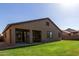 Spacious backyard showing a covered patio and a well-manicured lawn, ideal for relaxation and outdoor enjoyment at 14556 W Shaw Butte Dr, Surprise, AZ 85379