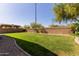 Wide backyard with a lush lawn and brick wall, perfect for outdoor activities and relaxing in a private setting at 14556 W Shaw Butte Dr, Surprise, AZ 85379