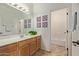 Clean bathroom with a large mirror, wooden vanity, and a view of the adjacent shower area at 14556 W Shaw Butte Dr, Surprise, AZ 85379