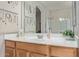Bright bathroom with a wooden vanity, a large mirror, and clean white countertops at 14556 W Shaw Butte Dr, Surprise, AZ 85379