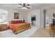 Spacious bedroom featuring a ceiling fan, painting, and a walk-in closet with an organized wardrobe at 14556 W Shaw Butte Dr, Surprise, AZ 85379