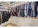 Organized walk-in closet with shelves for shoes and racks for hanging clothes at 14556 W Shaw Butte Dr, Surprise, AZ 85379