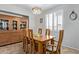Charming dining room featuring a wood table, six chairs, tile floors, and window with shutters at 14556 W Shaw Butte Dr, Surprise, AZ 85379