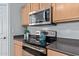 Modern kitchen featuring stainless steel appliances, a cooktop, and dark countertops at 14556 W Shaw Butte Dr, Surprise, AZ 85379