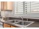Close up of stainless steel kitchen sink with white shuttered windows at 14556 W Shaw Butte Dr, Surprise, AZ 85379
