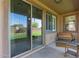 Covered patio with bench, side table, and a view to a grass-covered yard and beautiful sky at 14556 W Shaw Butte Dr, Surprise, AZ 85379