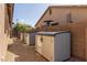 Side yard with outdoor storage sheds, gravel, and a block wall at 14556 W Shaw Butte Dr, Surprise, AZ 85379