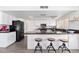 Bright eat-in kitchen featuring white cabinets, sleek black appliances, granite countertops and breakfast bar seating at 15212 N 53Rd St, Scottsdale, AZ 85254