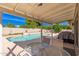 Inviting covered patio area overlooking a clear blue pool and lush landscaping at 15212 N 53Rd St, Scottsdale, AZ 85254