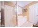 Bright bathroom featuring a walk-in shower, soaking tub, neutral tile and decorative wall art at 17225 N 51St Dr, Glendale, AZ 85308