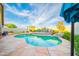 Backyard view of a swimming pool with a waterfall feature, lounge chairs, and mature landscaping at 17225 N 51St Dr, Glendale, AZ 85308