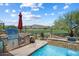 An outdoor kitchen and swimming pool overlook a golf course in this backyard oasis at 1788 W Dion Dr, Anthem, AZ 85086