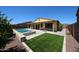 Inviting backyard with a pool, spa, covered patio, fire pit, and artificial turf at 17947 W Jojoba Rd, Goodyear, AZ 85338