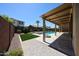 Resort-style backyard with a sparkling pool, fire pit, covered patio, and lush landscaping, perfect for entertaining at 17947 W Jojoba Rd, Goodyear, AZ 85338