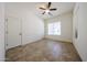 Bright, empty bedroom with tile floors, white walls, ceiling fan, and a window at 17947 W Jojoba Rd, Goodyear, AZ 85338