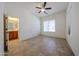 Bright bedroom with tile floors, ceiling fan, and an ensuite bathroom at 17947 W Jojoba Rd, Goodyear, AZ 85338