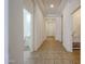 Bright hallway with tiled flooring, neutral walls, and access to the bathroom and a separate laundry area at 17947 W Jojoba Rd, Goodyear, AZ 85338
