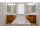 Bright main bathroom featuring dual vanities, a soaking tub and bright lights at 17947 W Jojoba Rd, Goodyear, AZ 85338