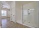 Bright main bathroom featuring a glass shower and open doorway to main bedroom at 17947 W Jojoba Rd, Goodyear, AZ 85338