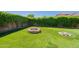 A firepit sits in the spacious backyard with artificial grass and mature landscaping at 18003 W Carmen Dr, Surprise, AZ 85388