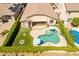 Aerial view of a home with a backyard featuring a pool, covered patio, manicured lawn, and privacy hedges at 18003 W Carmen Dr, Surprise, AZ 85388