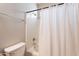 Bathroom with a standard toilet and a shower-tub combination featuring a white curtain at 18003 W Carmen Dr, Surprise, AZ 85388