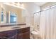 Bathroom with a granite countertop vanity, a standard toilet, and a shower-tub combination with a curtain at 18003 W Carmen Dr, Surprise, AZ 85388