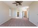 Large primary bedroom is carpeted with ceiling fan, and features access to the walk-in closet and ensuite at 18003 W Carmen Dr, Surprise, AZ 85388