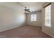 Spacious bedroom featuring neutral paint, carpet flooring, and a ceiling fan for comfortable living at 18003 W Carmen Dr, Surprise, AZ 85388