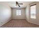 Bedroom with neutral walls, carpet flooring, ceiling fan, and a window providing natural light at 18003 W Carmen Dr, Surprise, AZ 85388