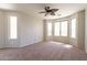Spacious bedroom with a ceiling fan and natural light from the windows at 18003 W Carmen Dr, Surprise, AZ 85388