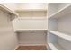 Walk-in closet with shelving units and carpeted flooring, offering ample storage space at 18003 W Carmen Dr, Surprise, AZ 85388