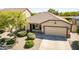 Single-story home featuring a two-car garage and a well-kept lawn at 18003 W Carmen Dr, Surprise, AZ 85388