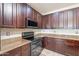 Beautiful kitchen featuring granite countertops, rich wood cabinetry, and stainless-steel appliances at 18003 W Carmen Dr, Surprise, AZ 85388