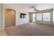 Bright living room features neutral walls, a ceiling fan, and access to the outdoor area at 18003 W Carmen Dr, Surprise, AZ 85388