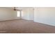 Bright living room with neutral carpeting, ceiling fan and natural light, creating a comfortable atmosphere at 18003 W Carmen Dr, Surprise, AZ 85388